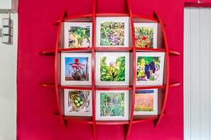 A red wall with a grid of framed pictures. - Vacation at the Winery – Apartment "Kleine Galerie" (Königheim)