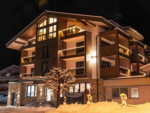 Ein mehrstöckiges Hotel mit Balkonen, einer Stein-Fassade und einem Schild mit der Aufschrift 'Lake Side Glockner'.