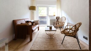 Ein Wohnzimmer mit einer Couch, einem Couchtisch und zwei Korbstühlen.