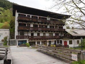 Un edificio de varios pisos con balcones, una terraza de madera y un letrero que indica propiedad privada.