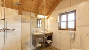 Kylpyhuone, jossa on suihku, pesuallas, wc ja ikkuna.