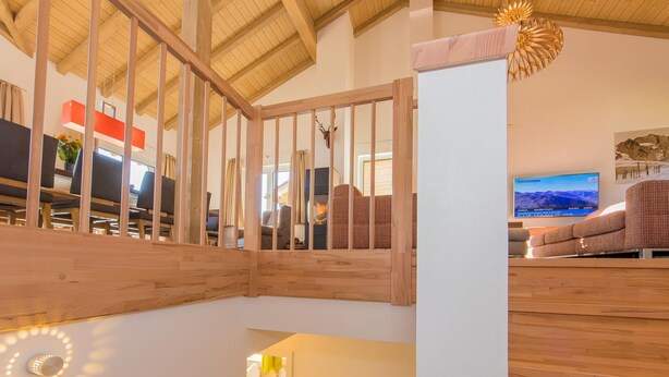 Un interior de madera con una escalera, un televisor y un sofá.