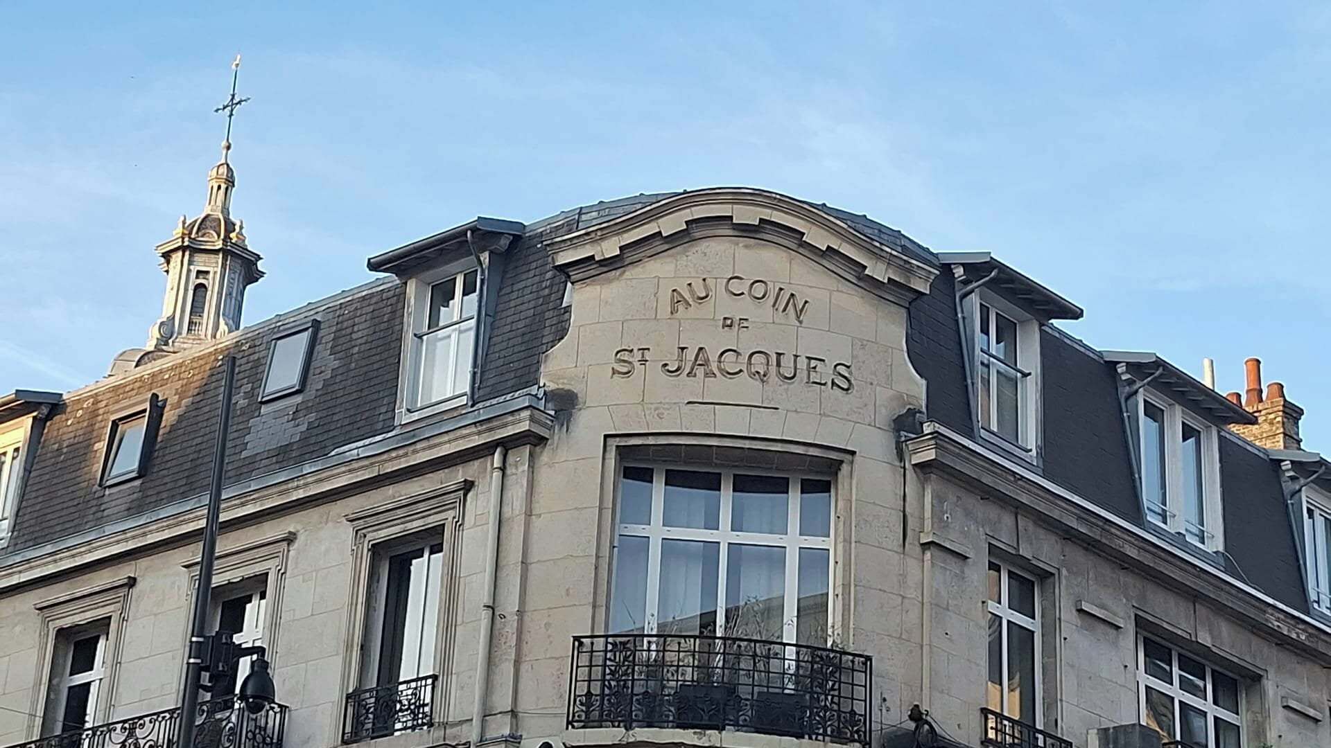 Um edifício com uma placa que diz 'Au Coin St Jacques'.