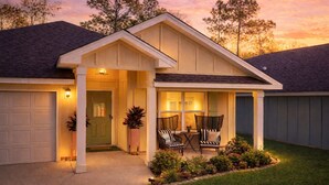 A residential house with a covered porch, a garage, and a well-maintained lawn. - Sleeps 12+ OWA Retreat: Backyard Bowling + Dogs (Foley)