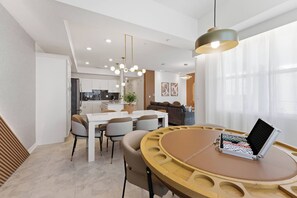A modern dining area with a round table, chairs, and a small table with a black object on it. - Storey Lake brand new near Disney lake & club view (Kissimmee)