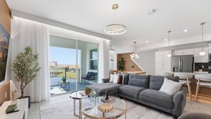 Een moderne woonkamer met een bank, salontafel en een eethoek.