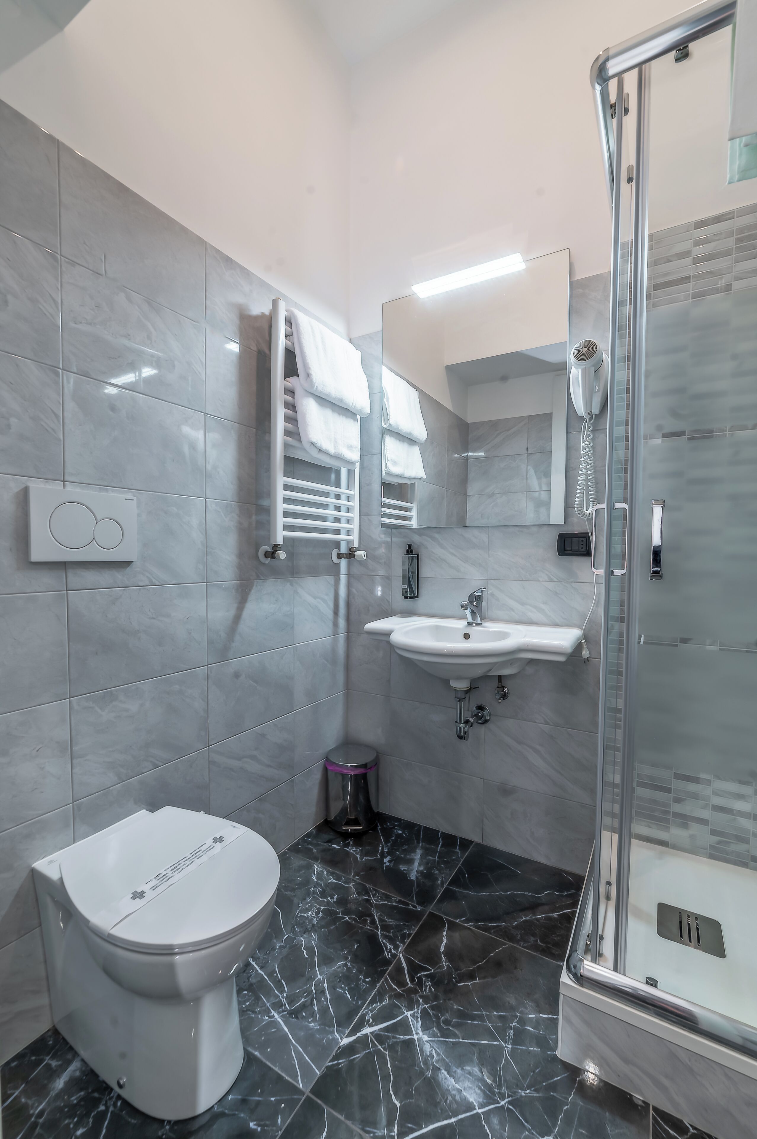 A bathroom with a toilet, sink, and shower.
