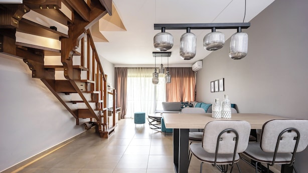 A modern living space with a staircase, dining area, and a sofa. - Charming Maisonette In Southern Suburbs (Voula)