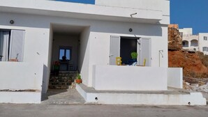 A modern white building with a flat roof, a small entrance, and a staircase leading to a door. - Apartment 'I Have A Dream' with Sea View, Private Terrace and Air Conditioning (Agia Pelagia)