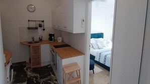 A compact room with a kitchenette, a bed, and a small seating area. - Apartment 'I Have A Dream' with Sea View, Private Terrace and Air Conditioning (Agia Pelagia)