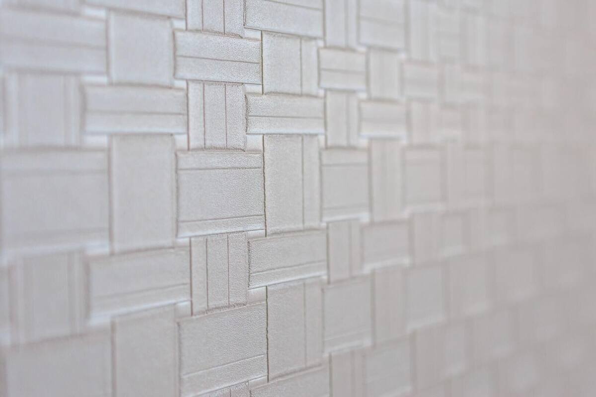 Un gros plan d’un mur à la texture particulière, avec un motif de briques.