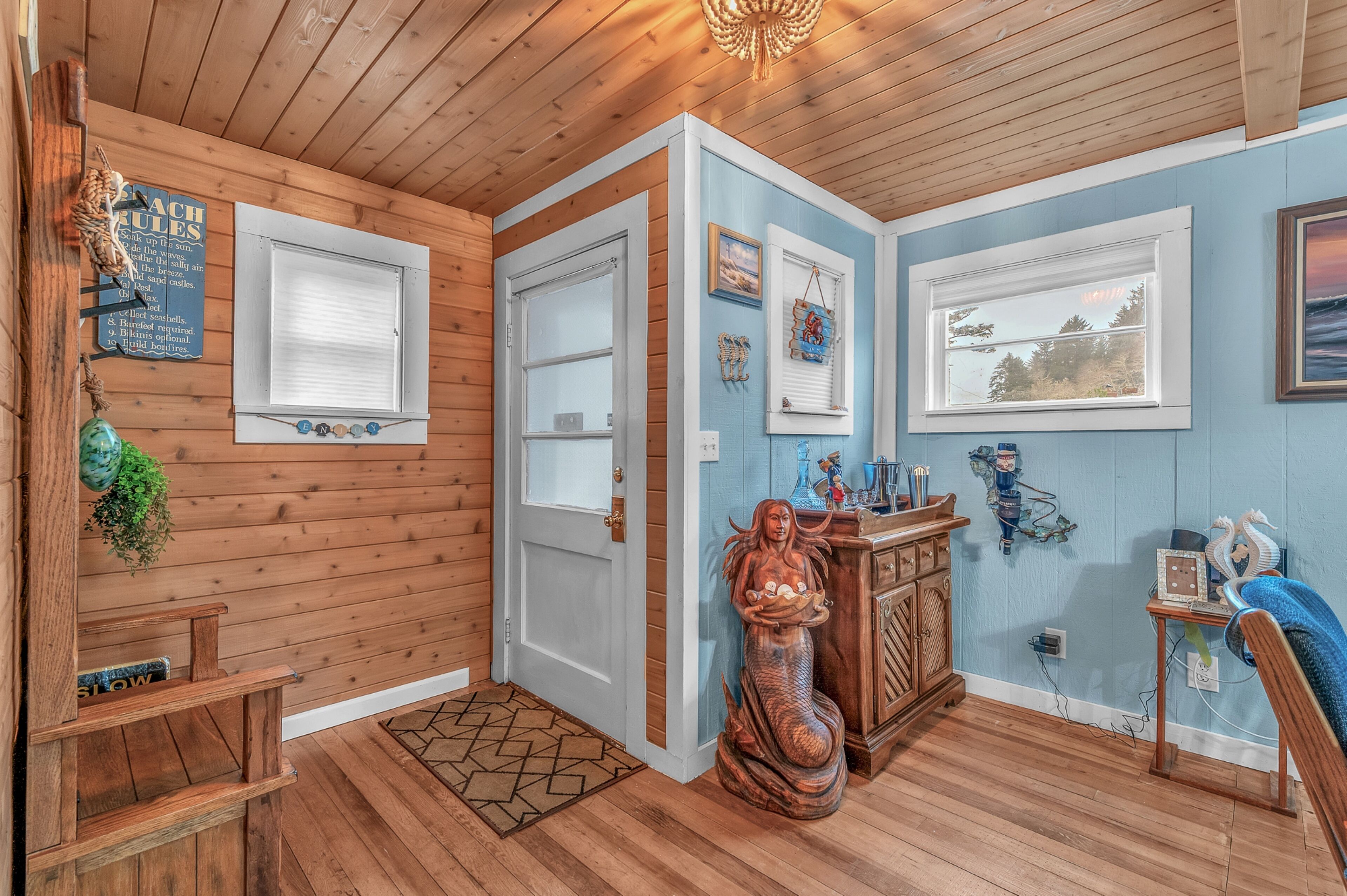 A wooden interior with a door, windows, a statue, and wall decorations.