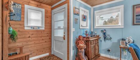 A wooden interior with a door, windows, a statue, and wall decorations.