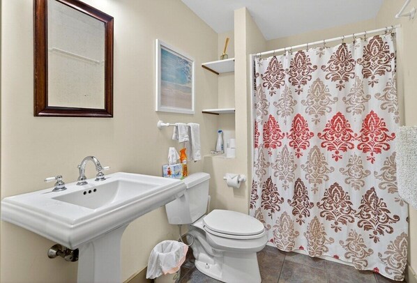 Ein Badezimmer mit Waschbecken, Toilette und Duschvorhang.