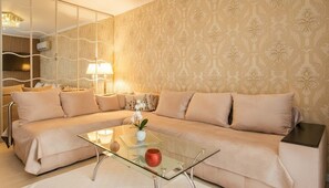 A living room with a beige sofa, a glass coffee table, and a patterned wallpaper. - Glyfada Athens Riviera Stylish Home with Parking (Glifada)