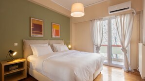 Ein Schlafzimmer mit Bett, Nachttisch und einem Fenster mit Vorhängen.