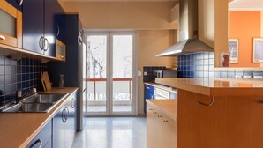Eine moderne Küche mit einem eingebauten Backofen, einer Edelstahl-Spüle und einem großen Fenster.