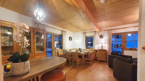 Un interior de madera con comedor, sofá y cocina.