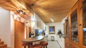 Una cocina con armarios de madera, una barra y un ventanal.