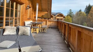 A wooden deck with a lounge area, a table, and chairs. - 6_ALP - Penthouse Preber by Interhome (Mariapfarr)
