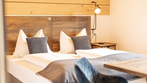 A bedroom with a wooden headboard, a bedside table, a lamp, and a bed with pillows. - 6_ALP - Penthouse Preber by Interhome (Mariapfarr)
