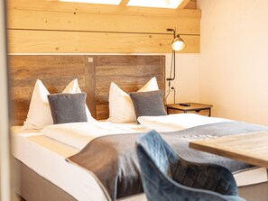 A bedroom with a wooden headboard, a bedside table, a lamp, and a bed with pillows. - 6_ALP - Penthouse Preber by Interhome (Mariapfarr)