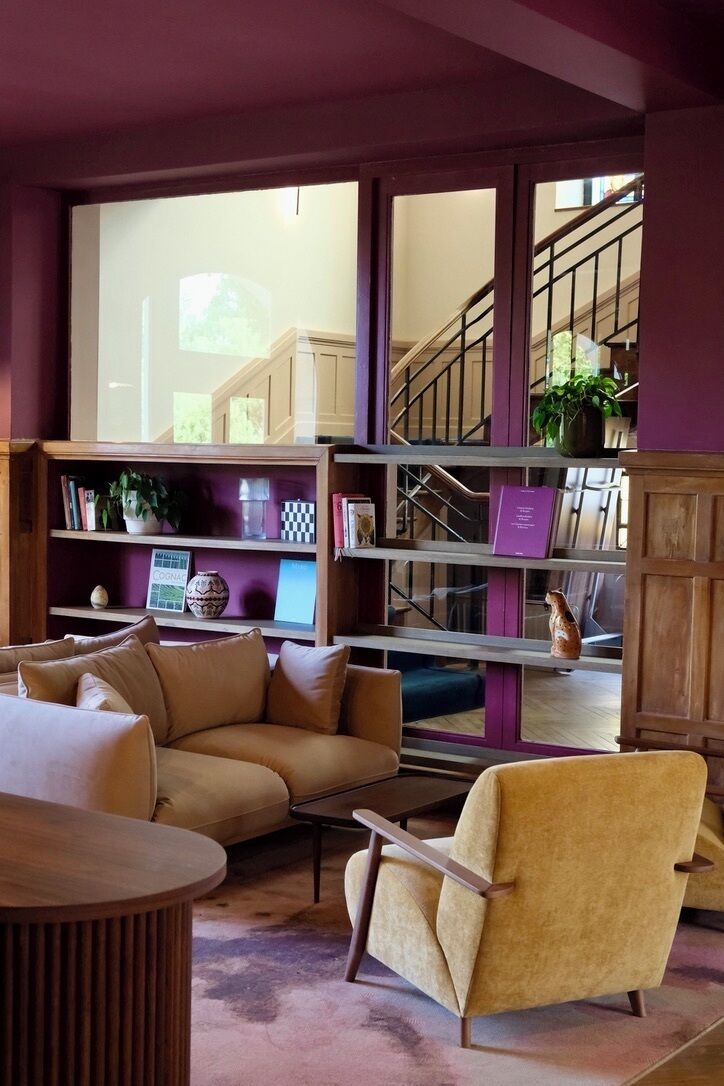 Een woonkamer met een bank, fauteuil en een boekenkast.