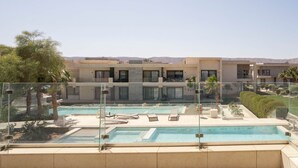 Zona de piscina en la azotea con vistas despejadas a edificios modernos y un paisaje desértico.