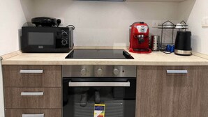 Una cocina equipada con microondas, cafetera y horno.