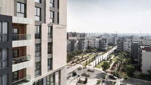 A high-rise residential building with multiple balconies, a landscaped courtyard, and a view of the cityscape. - AEON Towers Lucky Cloud #606 - nesty (6th of October City)