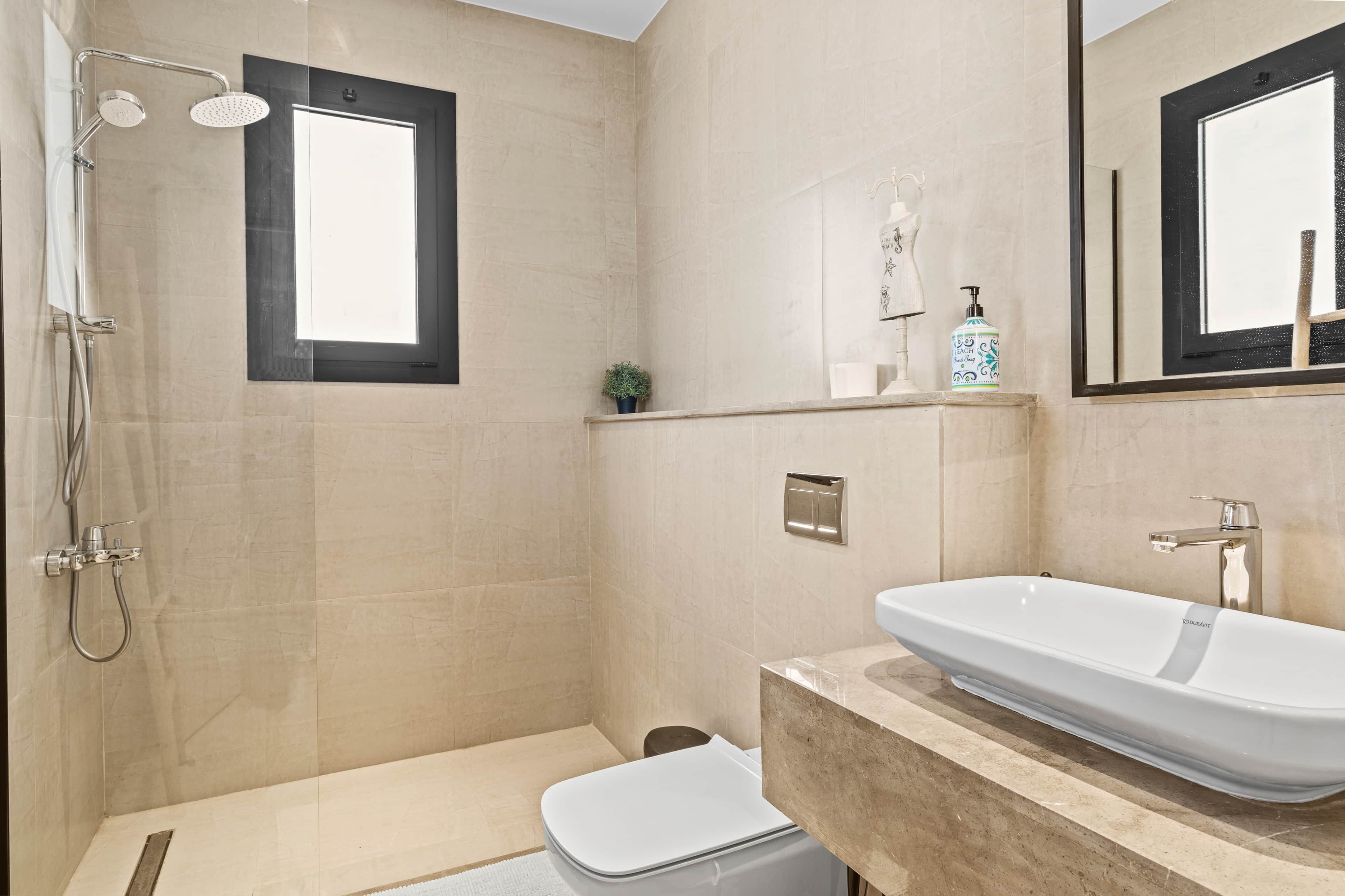 Ein modernes Badezimmer mit Badewanne, Toilette, Dusche und einem großen Spiegel.