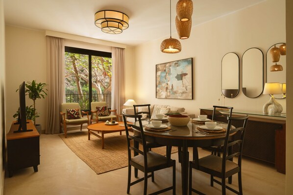 Un salon comprenant un coin repas, un canapé, une table basse et un meuble pour la télévision.