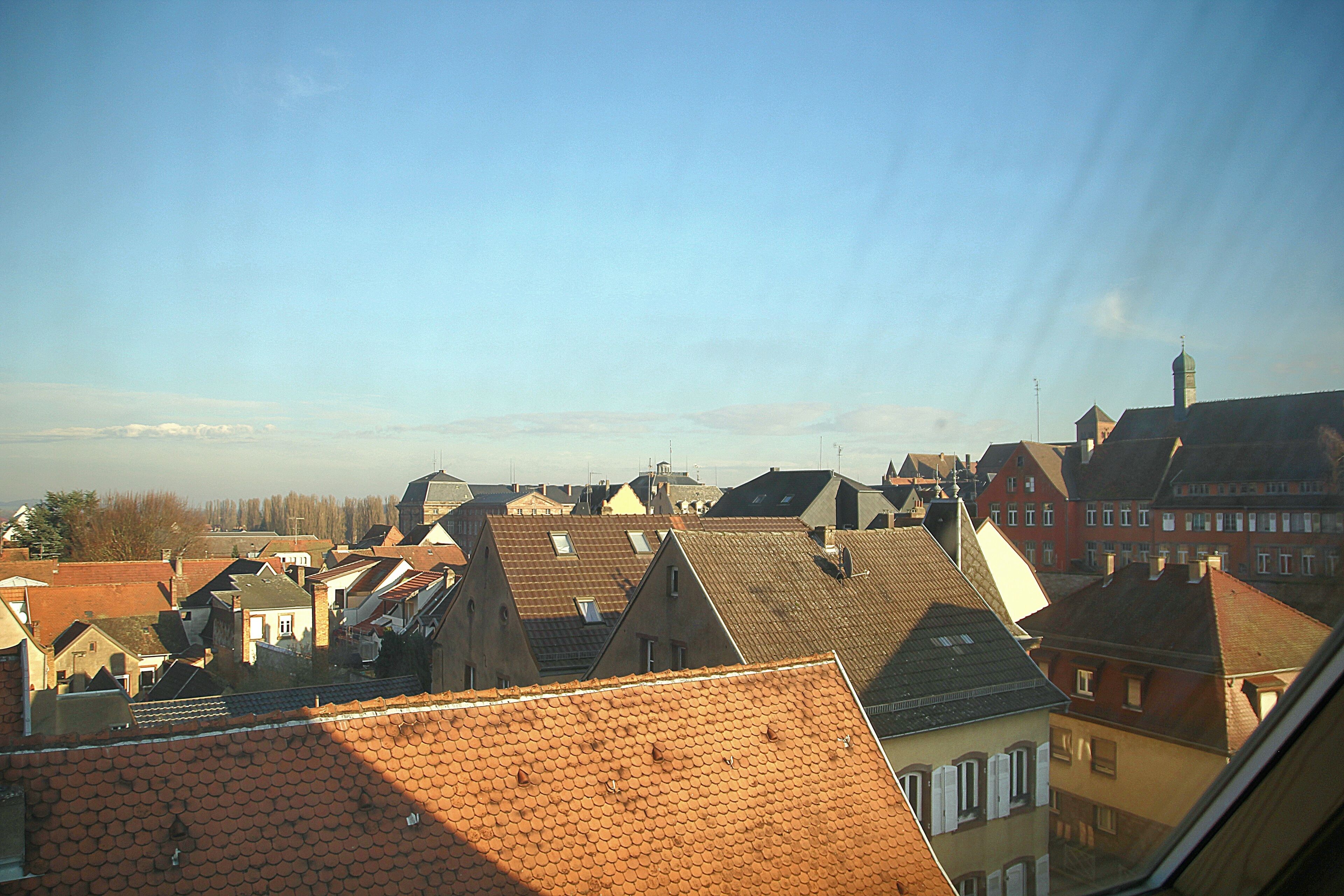 A view of a town with various buildings, including houses and a church with a tall steeple.