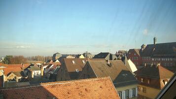 A view of a town with various buildings, including houses and a church with a tall steeple.