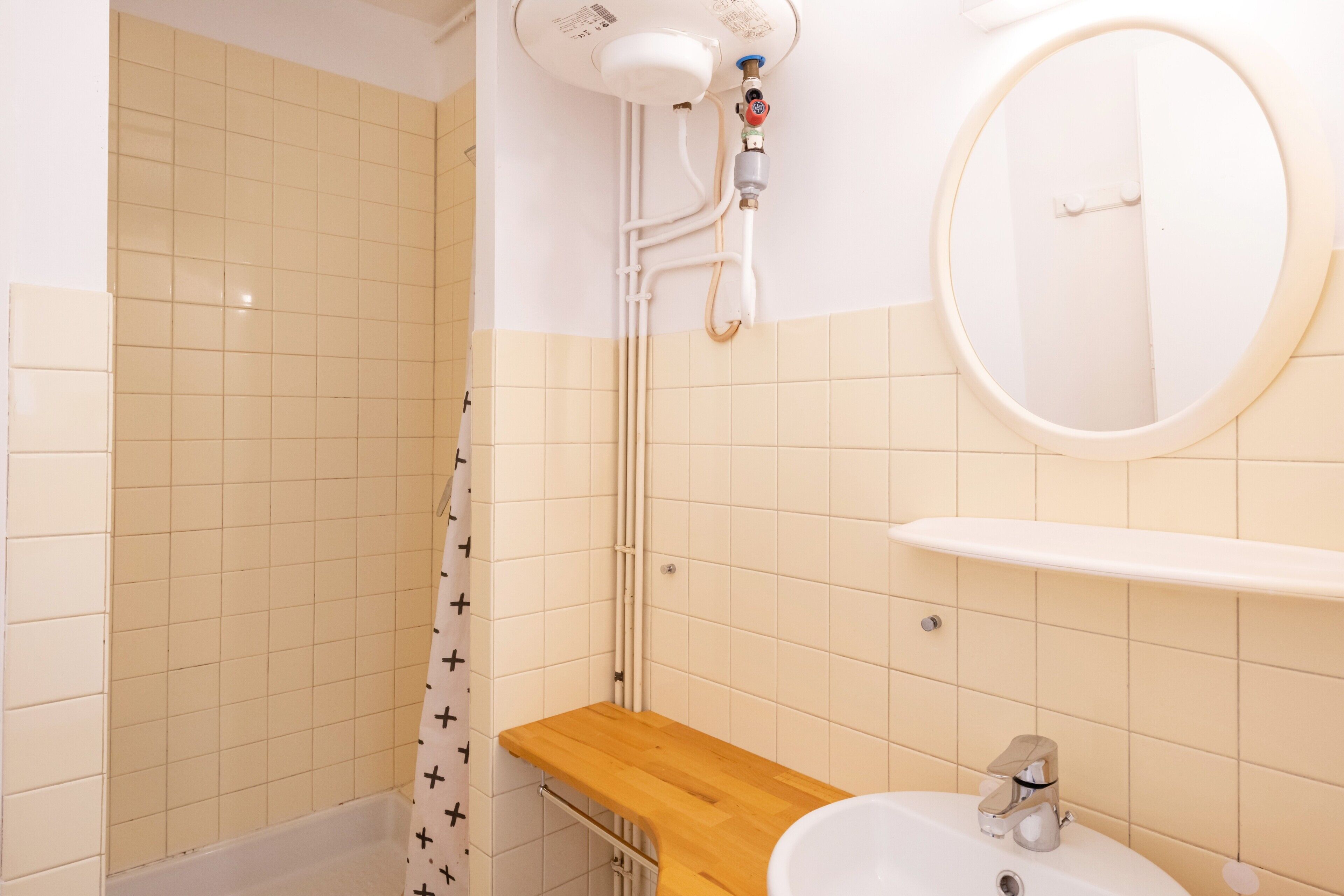 Ein Badezimmer mit Dusche, Waschbecken und Spiegel.