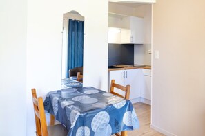 A small kitchenette with white cabinets and a countertop. - Cozy Studio with Private Terrace, Air Conditioning & Pool Table – Cazaubon (Cazaubon)