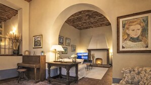 A cozy living room with a fireplace, a television, and a large painting. - Villa Casale Belvedere by Interhome (Monsummano Terme)