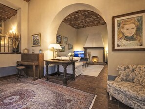 Un accogliente soggiorno con camino, televisione e un grande quadro.