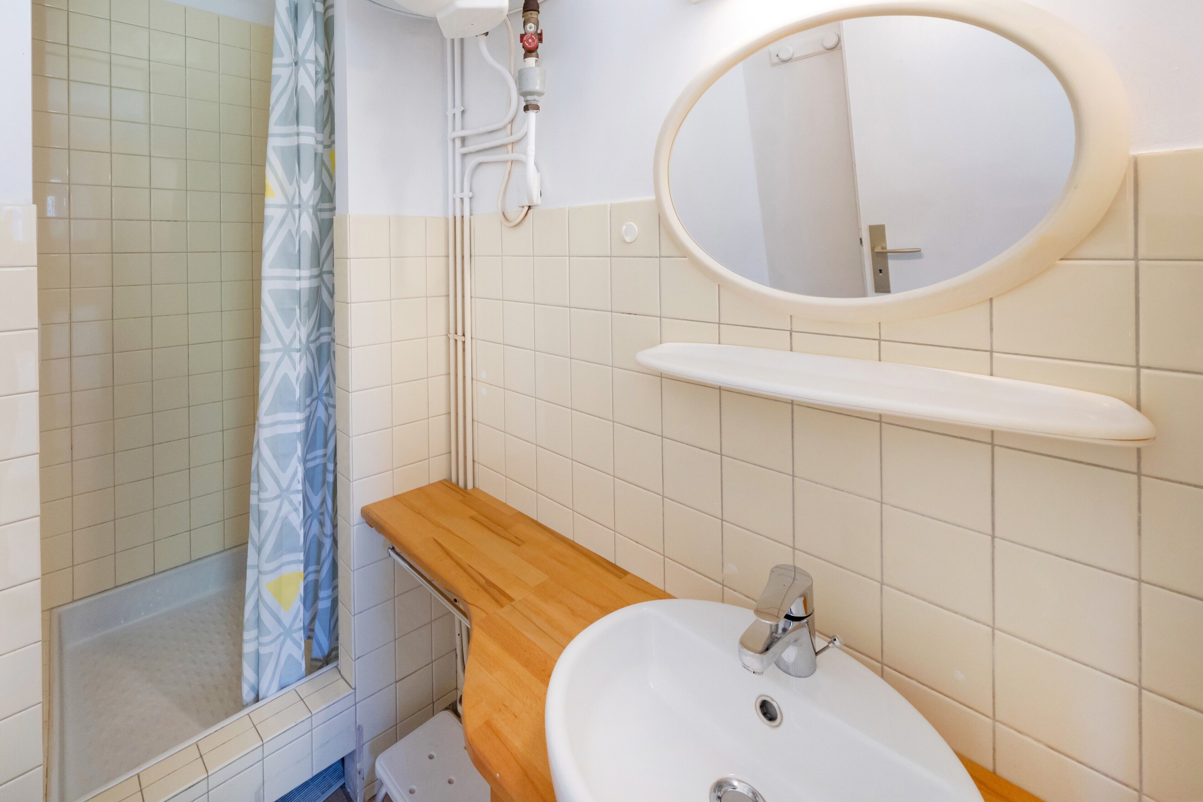 Une salle de bain équipée d’une douche, d’un lavabo, d’un miroir et de toilettes.