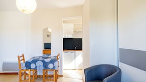 A compact living space with a dining area, kitchenette, and a seating area. - Cozy Studio with Private Terrace, Air Conditioning & Pool Table – Cazaubon (Cazaubon)