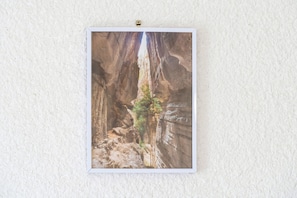 Une photographie encadrée représentant un canyon avec un étroit passage et un arbre.
