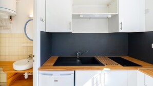 A modern kitchen with a sink, countertop, and cabinets. - Cozy Studio with Private Terrace, Air Conditioning & Pool Table – Cazaubon (Cazaubon)
