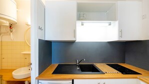 A kitchen with a sink, stove, and cabinets. - Cosy Studio with Balcony, Air Conditioning & Pool Table – Cazaubon (Cazaubon)