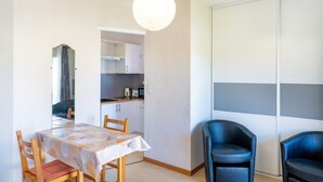 A dining area with a table, chairs, and a hanging light fixture. - Cosy Studio with Balcony, Air Conditioning & Pool Table – Cazaubon (Cazaubon)