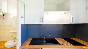 A modern kitchen with a sink, stove, and cabinets. - Cosy Studio with Balcony, Air Conditioning & Pool Table – Cazaubon (Cazaubon)