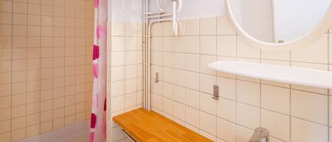 Un baño con bañera, tocador de madera, lavabo y espejo.