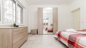 A bedroom with a bed, a dresser, a mirror, and a window. - Luca Flat - Tiburtina Train Station (Rome)