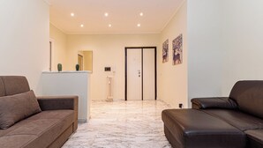 A modern living room with two sofas, a marble floor, and a door leading to another room. - Luca Flat - Tiburtina Train Station (Rome)