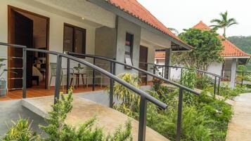 A modern house with a red-tiled roof, a covered porch, and a staircase leading to a second level.