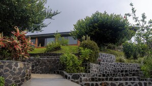 A stone staircase leading to a house with a garden and a view of the sky. - Hotel Alto Monte (Chiguirí Arriba)